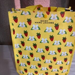 Marc Jacobs Daisy Yellow Tote 
is Stuffed With Several Items inside.